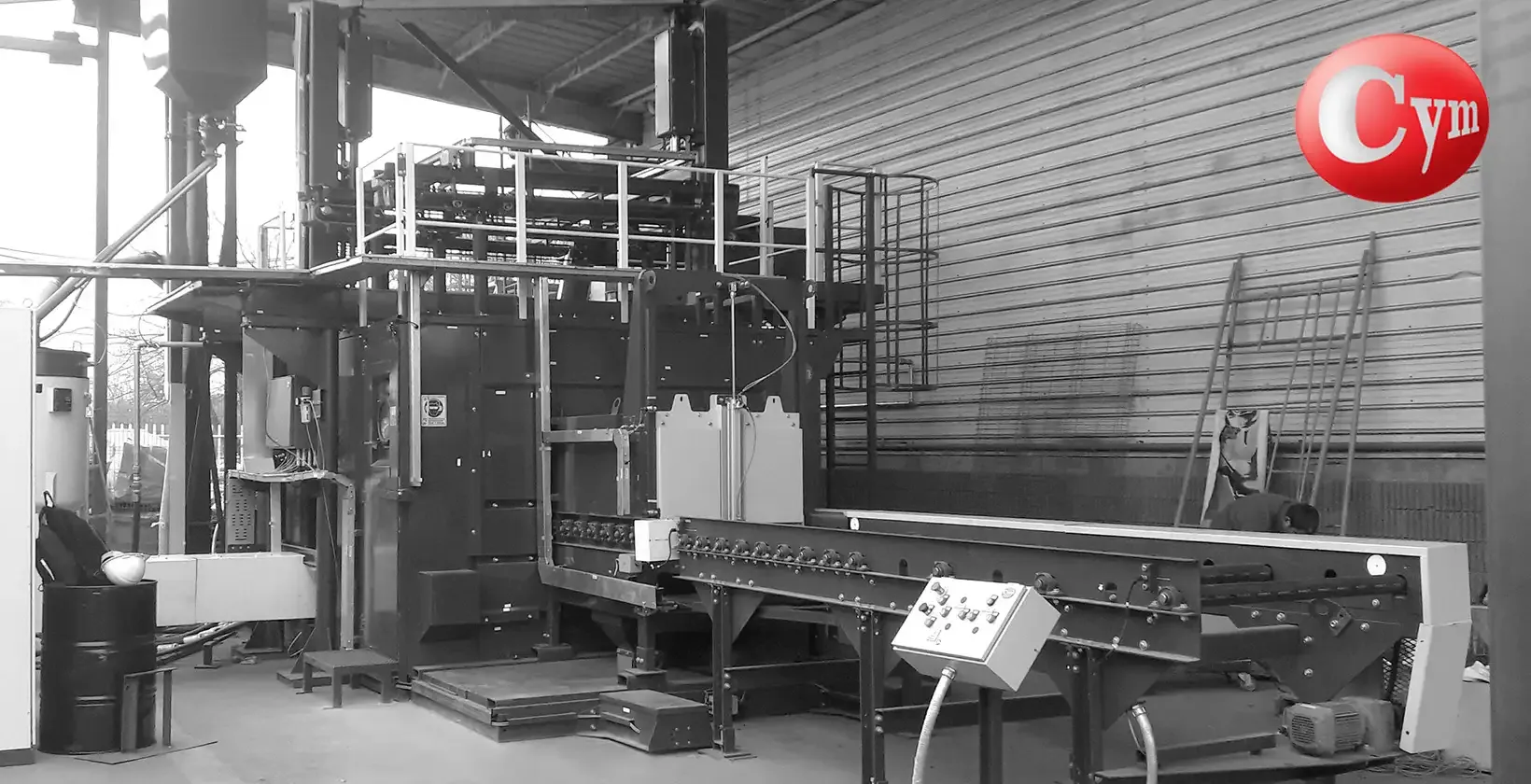 Cuarto granallado automático CYM instalado planta Tega Industries Chile — transportador salida piezas