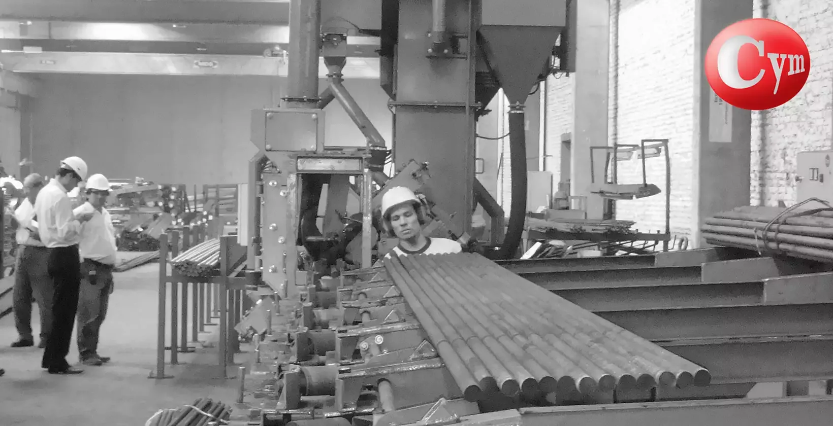 CYM BAR 2 bar blaster at Rogiro Aceros, Argentina – operator and supervisors arranging bars on accumulation table before loading onto roller conveyor