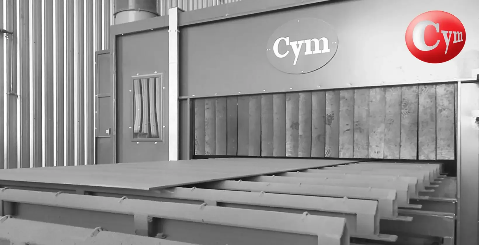 CYM CH 2.5H line shop primer drying oven exit – steel plates with grey primer on chain conveyor · Astillero Paraná Sur, Argentina