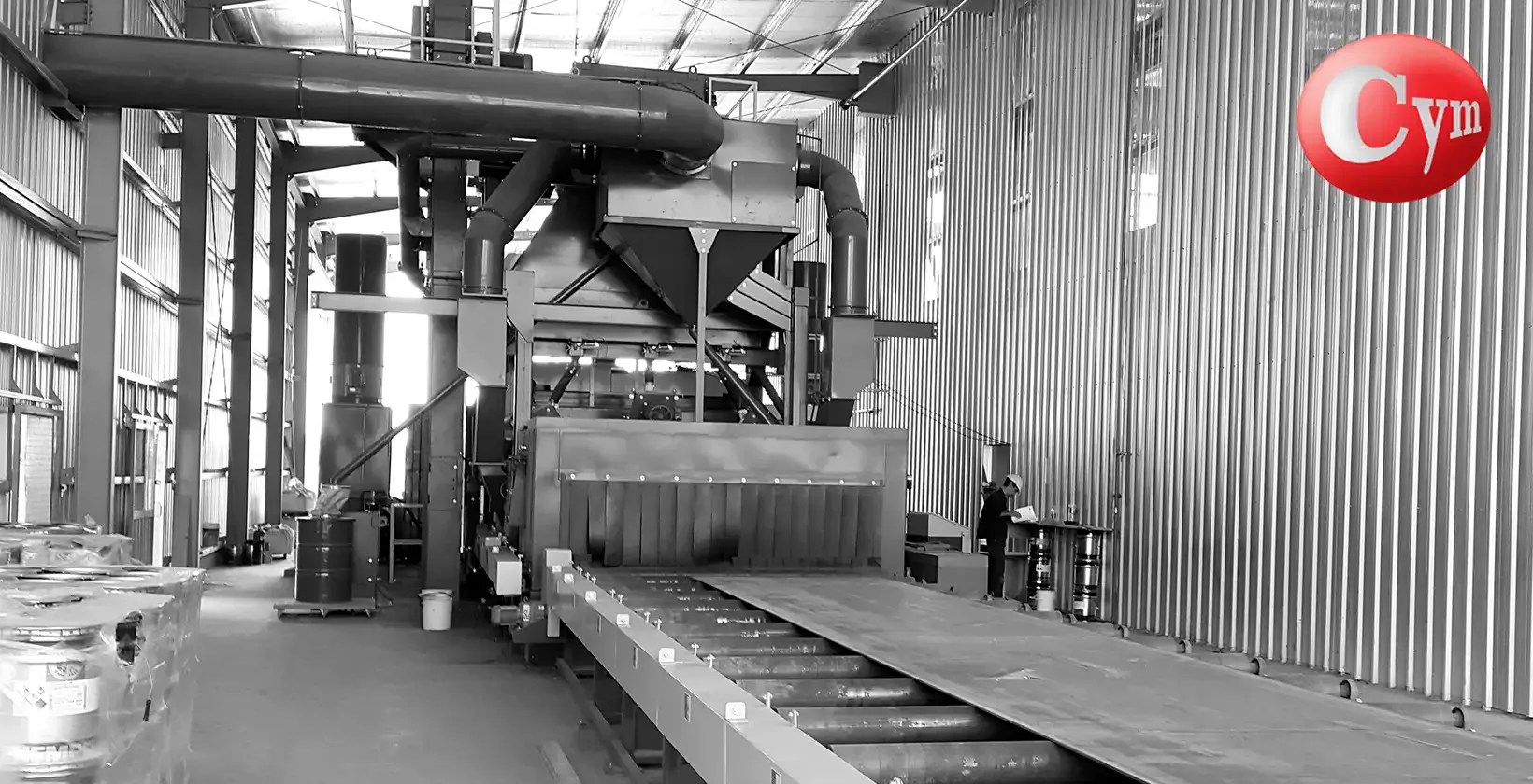 CYM CH 2.5H horizontal plate blaster – front view of blast cabinet with steel plate entering on roller conveyor · Astillero Paraná Sur, Argentina