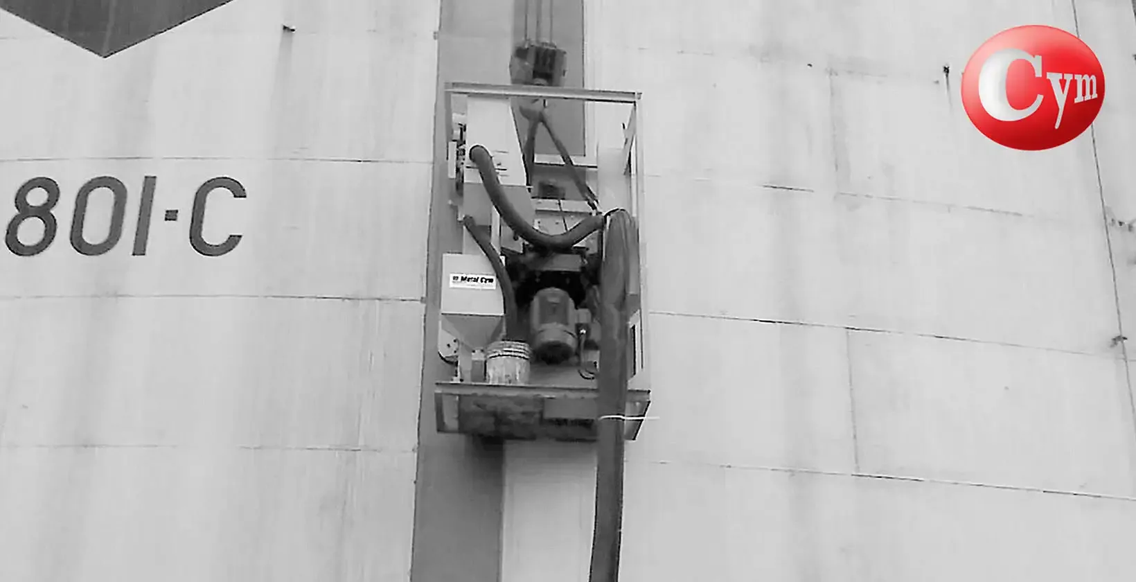 METALCYM portable blast machine suspended on vertical rail on storage tank exterior wall, 30 HP blast wheel