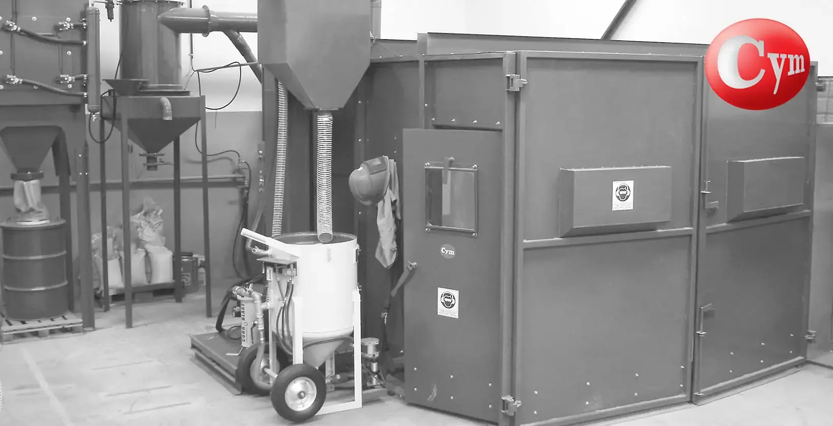 CYM Materiales ARC Compacto abrasive separator next to blast cabinet in small blast room with blast pot and hoppers