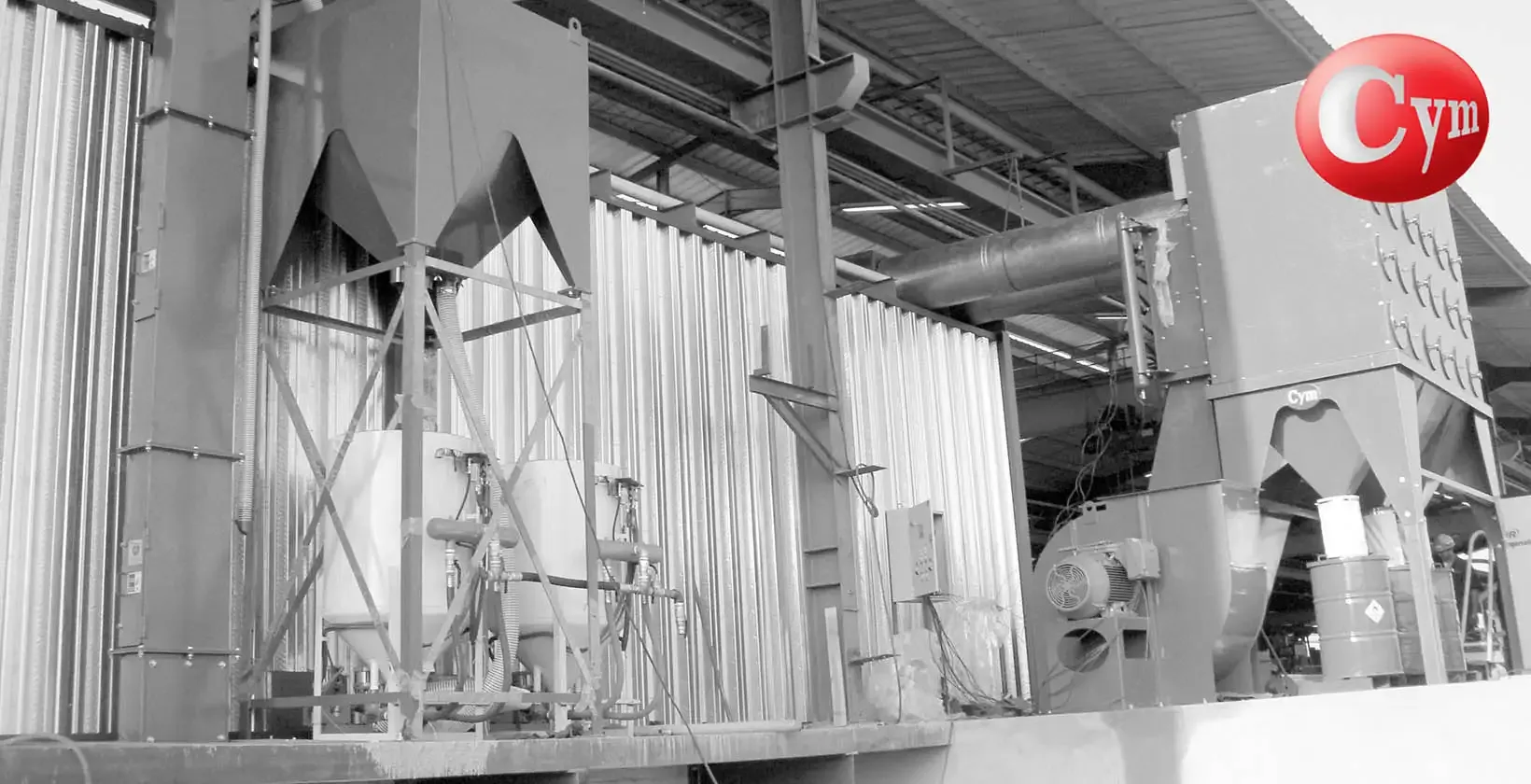 CYM Materiales ARC Stationary abrasive separator next to two large capacity blast rooms in industrial installation