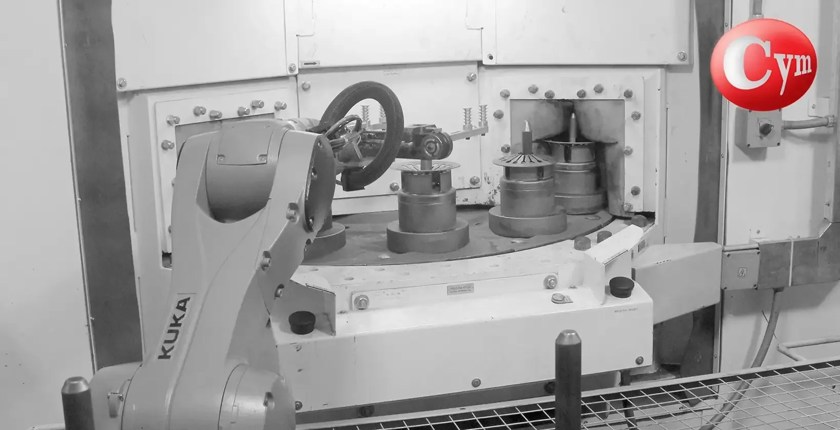 CYM Materiales SAT12-1TR50HP: KUKA loading robot positions clutch disc, 3 spindles in front of 50 HP blast wheel