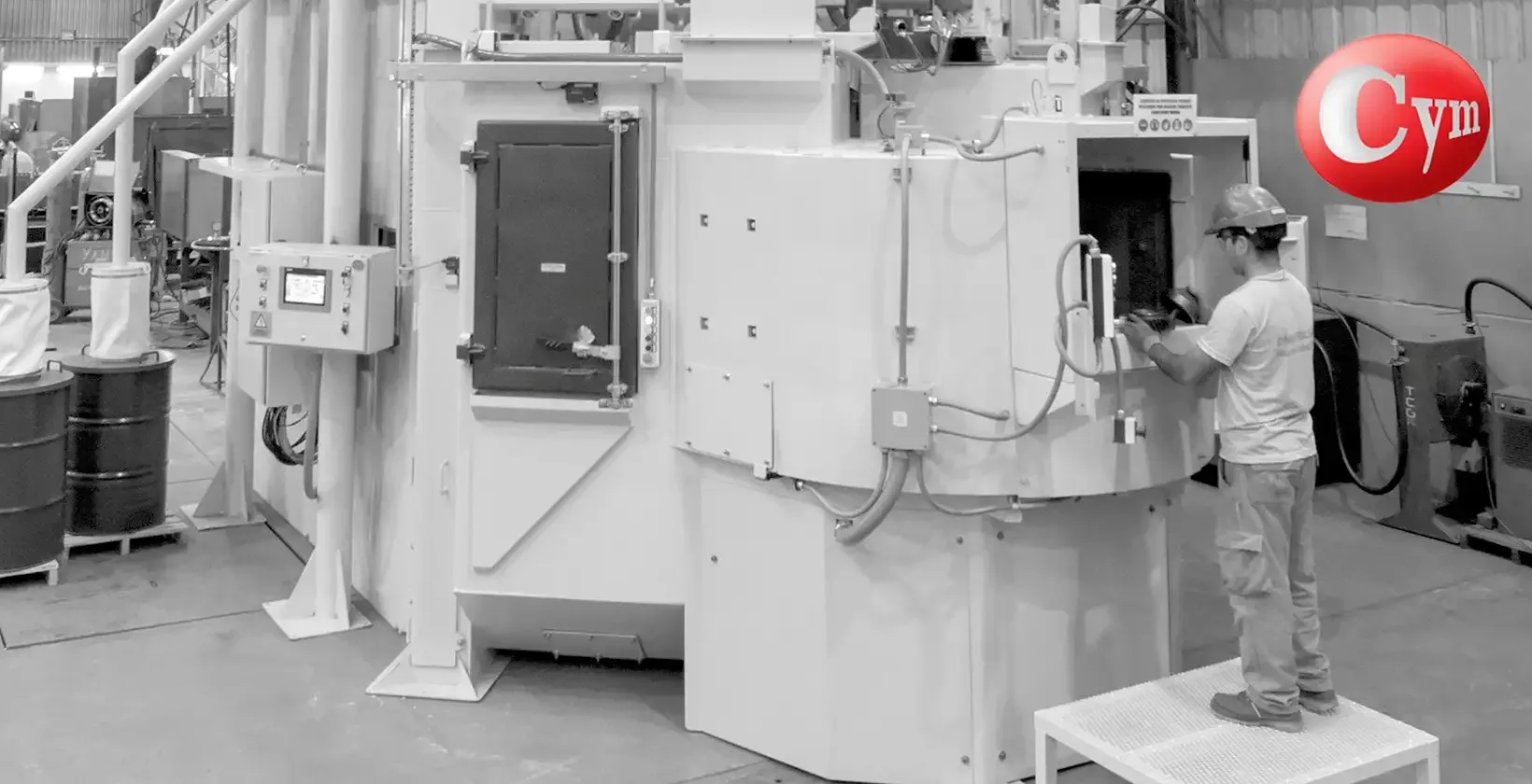 FAT test operator loading gears into CYM SAT 7-2SP machine with dual-chamber hoppers and Kuka servo motor